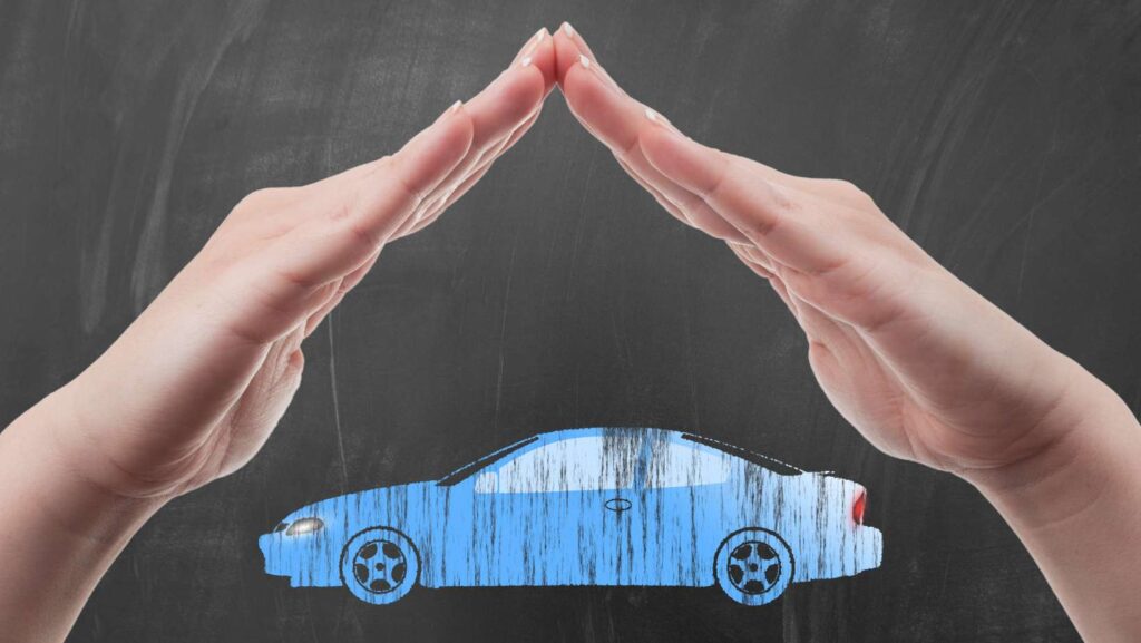 Hands protecting car shape as auto insurance concept