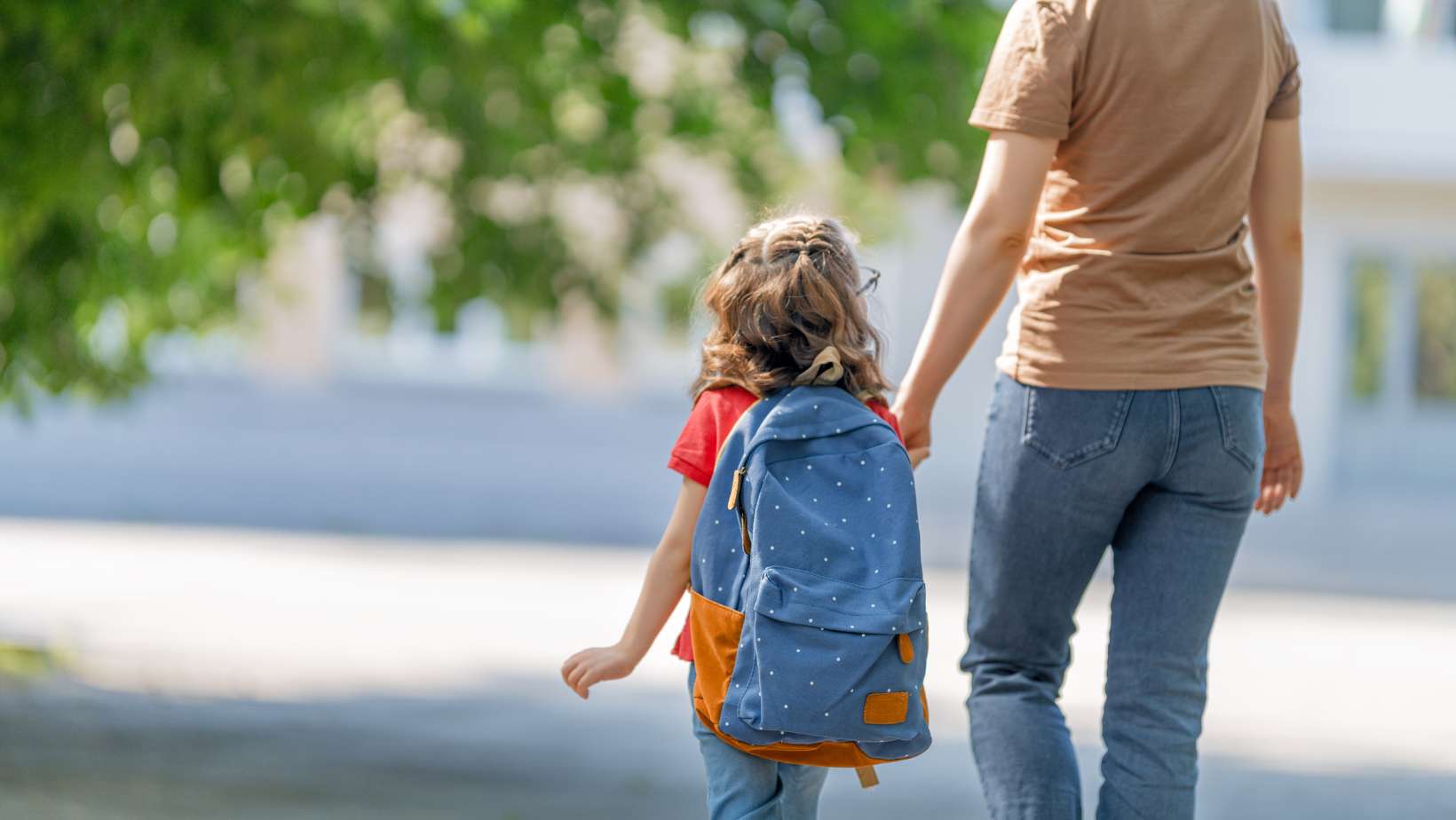 Parent and pupil going to primary school hand in hand