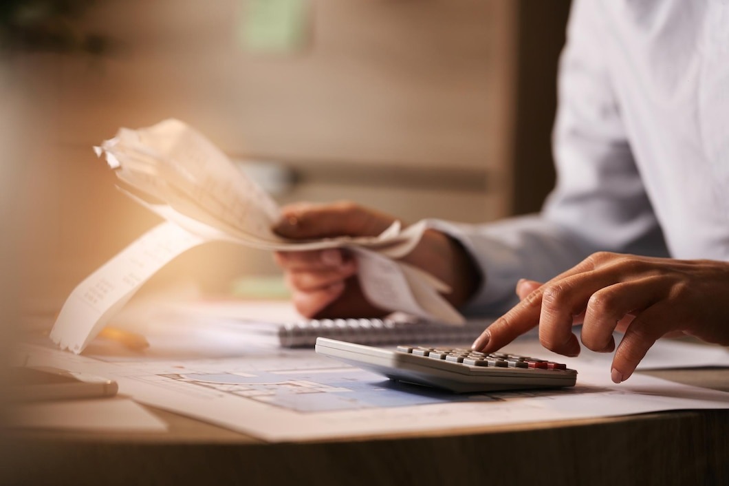 economist using calculator while going through bills and taxes in the office