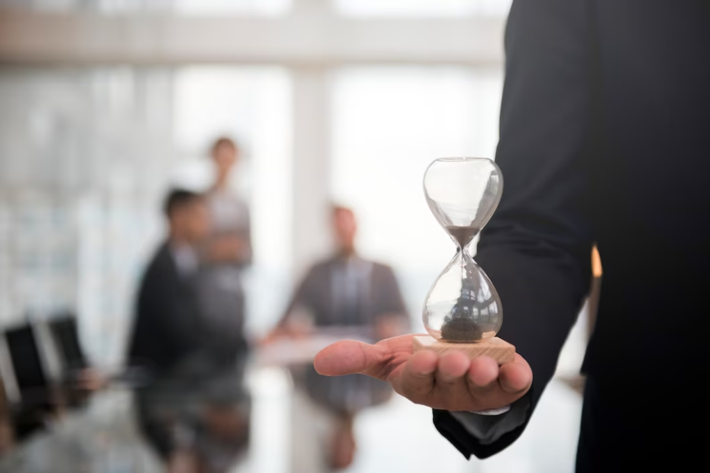 businessman holding an hour glass, signifies the importance of being on time